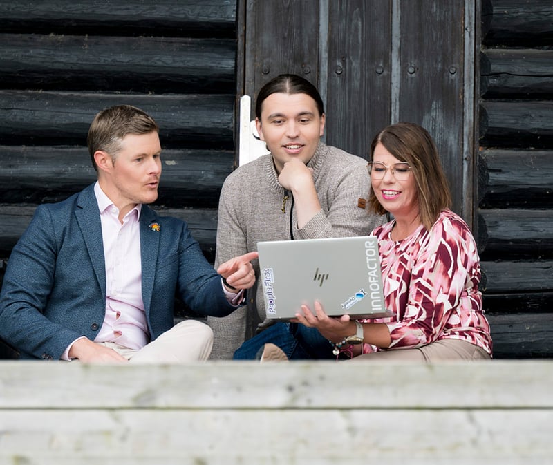 KSP people outdoors at the sauna looking at laptop