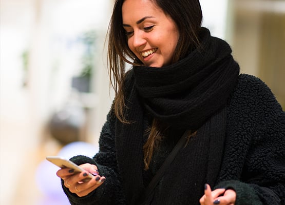 ksp-m-555x400-more_personal_customer_experience_lady_with_phone_in_winter_clothing